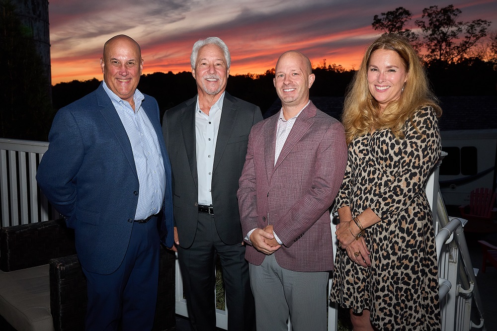 Executive Team in front of a sunset. From left to right, Bob Richards, COO, Scott Stevenson, President & CEO, Tom Baer, CFO, and Michell Staska-Pier, VP of Healthcare Services.
