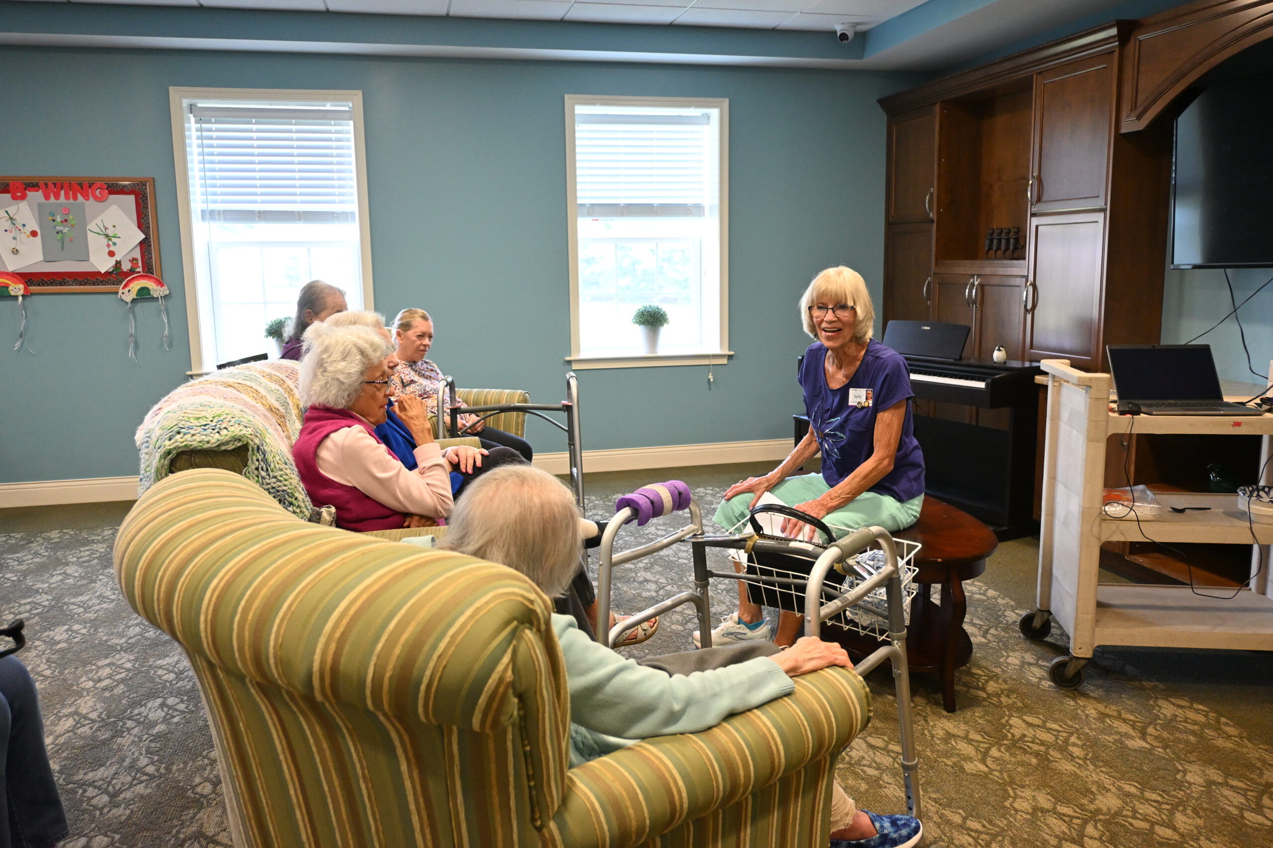 Community Life Assistant Sally Spear leads residents through historical facts before watching old movie clips at Phoebe Richland.
