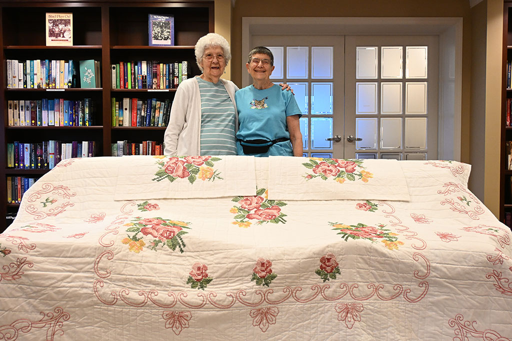 Residents and quilt contributors Fran Sletvold and Jeanette Roth with the full quilt.