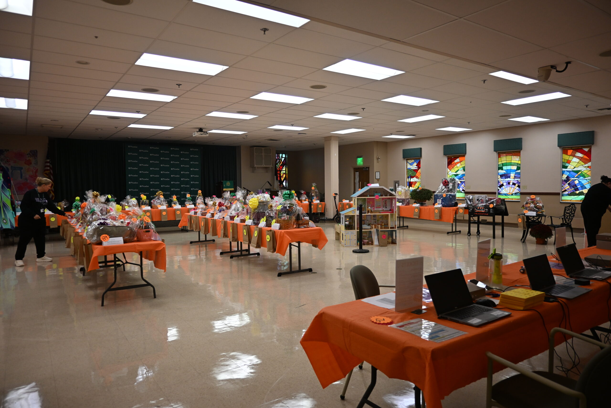 A wide shot of Phoebe Allentown's Moyer Hall with over 90 Basket Social baskets lining orange tables.