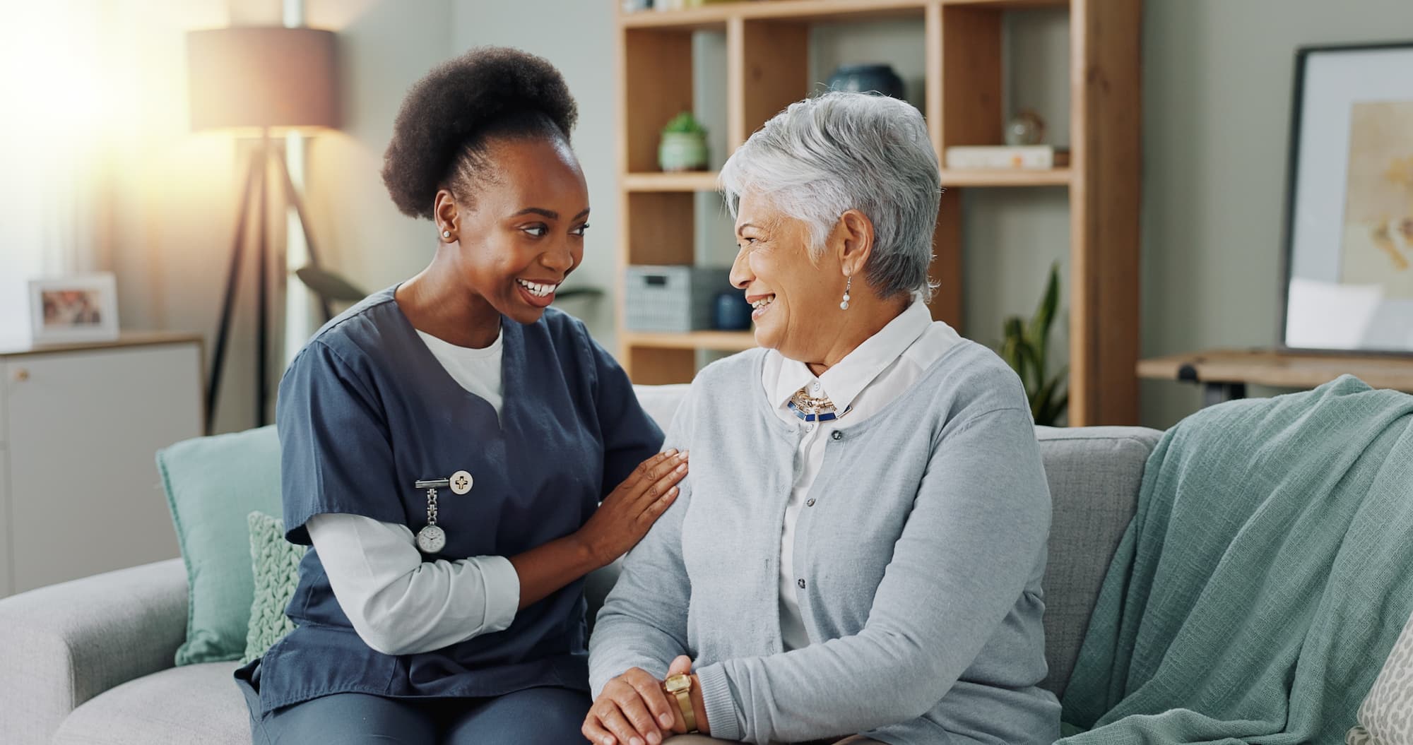 Elder women in nursing home talking to nurse.